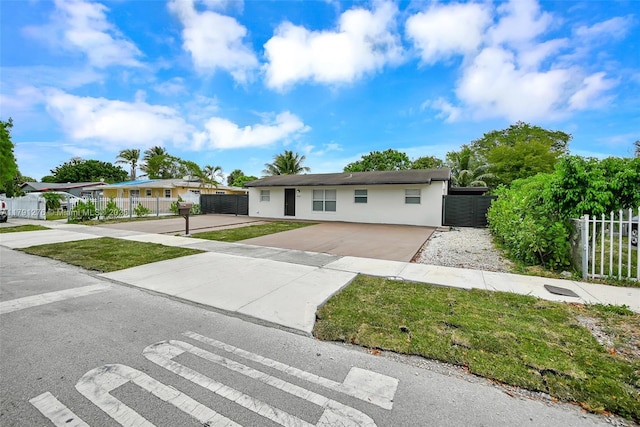 single story home featuring fence, stucco siding, and concrete driveway