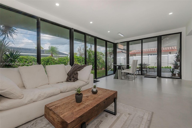 living room featuring recessed lighting, a wall of windows, and plenty of natural light
