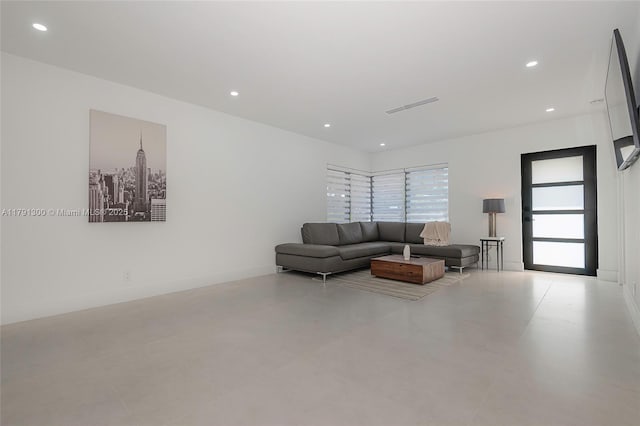 living room with finished concrete flooring, visible vents, and recessed lighting
