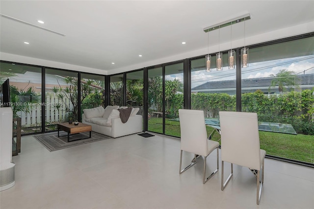 sunroom with recessed lighting, a wall of windows, and plenty of natural light