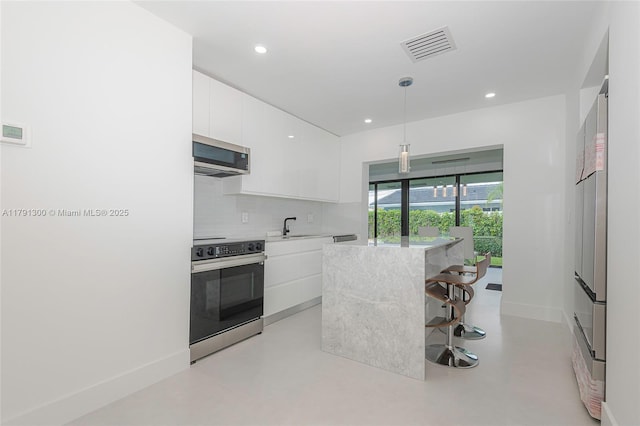 kitchen featuring white cabinetry, appliances with stainless steel finishes, visible vents, light countertops, and modern cabinets