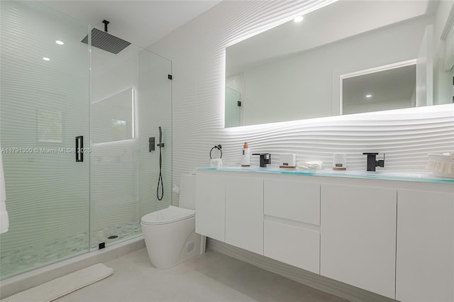 bathroom with toilet, a stall shower, double vanity, and a sink