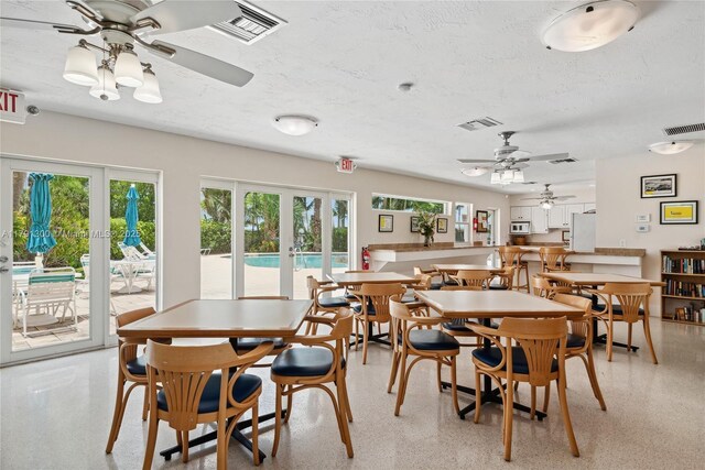 dining room with a textured ceiling, ceiling fan, french doors, and visible vents