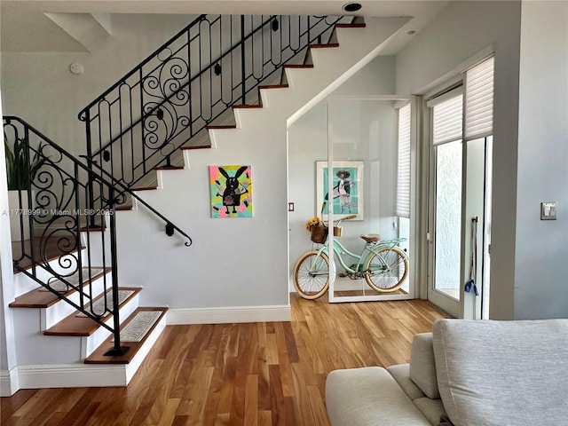 entrance foyer with baseboards, stairway, and wood finished floors