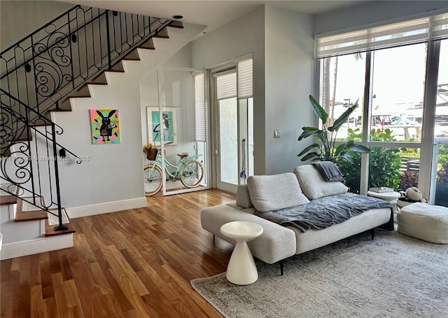 interior space with baseboards, stairway, wood finished floors, and a healthy amount of sunlight