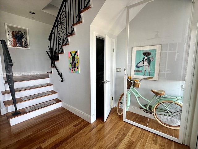stairway with wood finished floors and baseboards