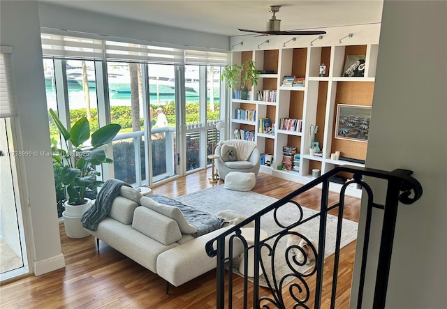 living area with wood finished floors and ceiling fan
