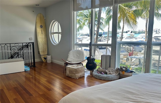 bedroom featuring multiple windows, wood finished floors, and baseboards