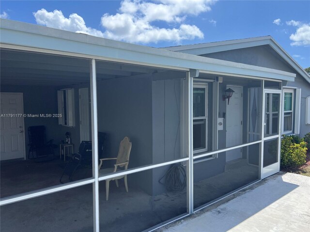 view of property exterior with a sunroom