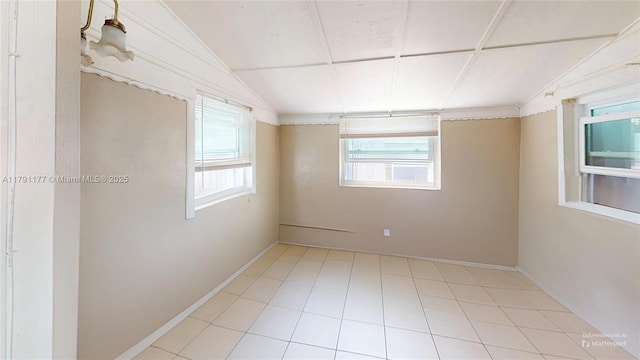 unfurnished room featuring baseboards and lofted ceiling