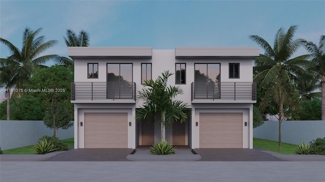 contemporary house featuring a garage, stucco siding, and a balcony