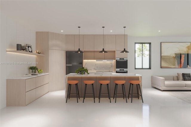 kitchen featuring double oven, a breakfast bar, freestanding refrigerator, modern cabinets, and an island with sink