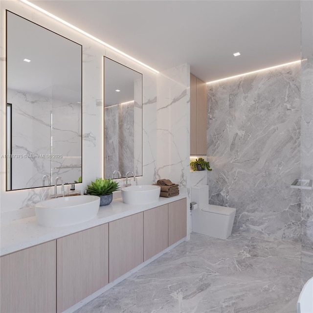 full bath featuring tile walls, marble finish floor, toilet, and a sink