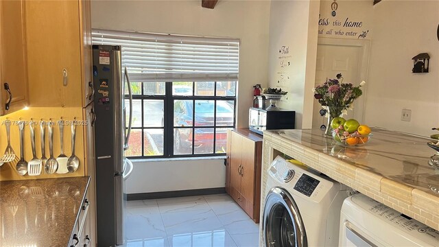 laundry area with washing machine and clothes dryer, laundry area, and marble finish floor