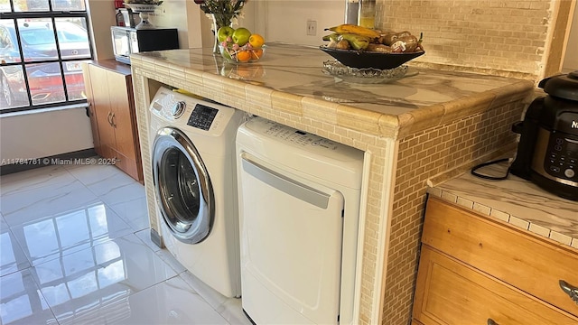 washroom featuring laundry area and washing machine and clothes dryer