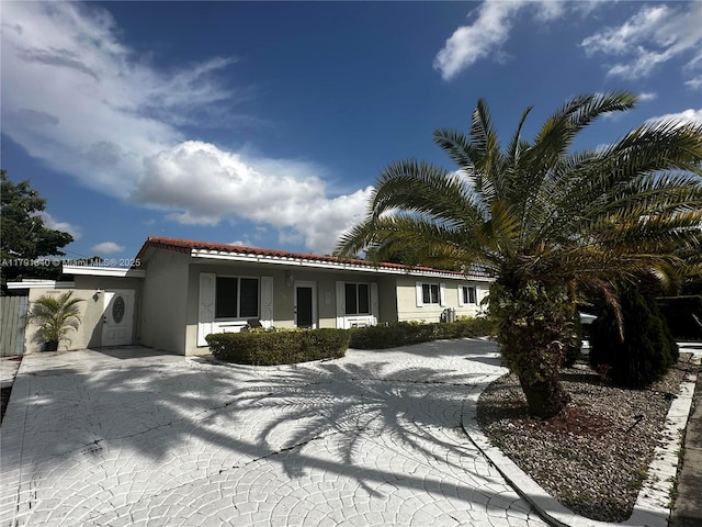 mediterranean / spanish house with a tile roof, driveway, and stucco siding