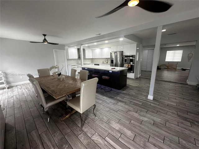 dining area with a ceiling fan, dark wood-style flooring, visible vents, and baseboards