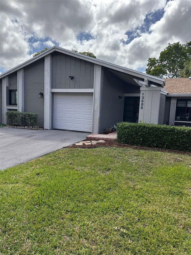 13686 SW 116th Ln, Miami, FL 33186 - view of side of property with driveway, a yard, and an attached garage