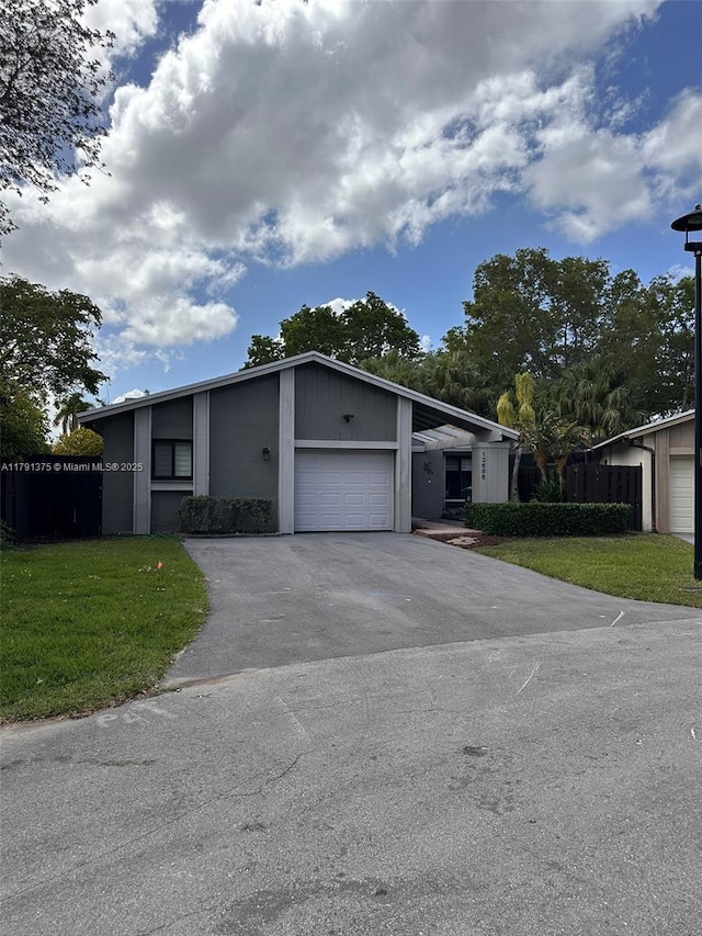 13686 SW 116th Ln, Miami, FL 33186 - view of front facade featuring a front lawn, driveway, an attached garage, and fence