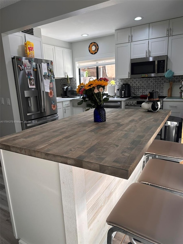 13686 SW 116th Ln, Miami, FL 33186 - kitchen featuring recessed lighting, wood counters, backsplash, a kitchen island, and appliances with stainless steel finishes