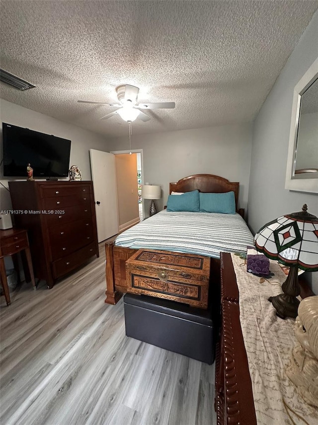 13686 SW 116th Ln, Miami, FL 33186 - bedroom with a textured ceiling, visible vents, a ceiling fan, and light wood-style flooring