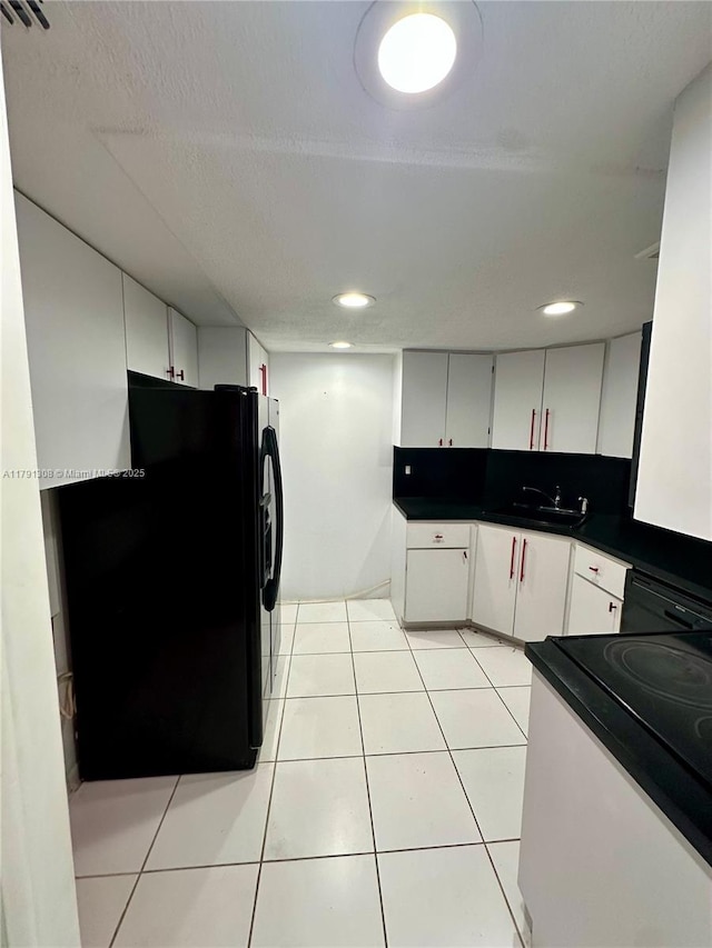 3301 Spanish Moss Ter Unit 302, Lauderhill, FL 33319 - kitchen with freestanding refrigerator, range, dark countertops, a sink, and white cabinetry