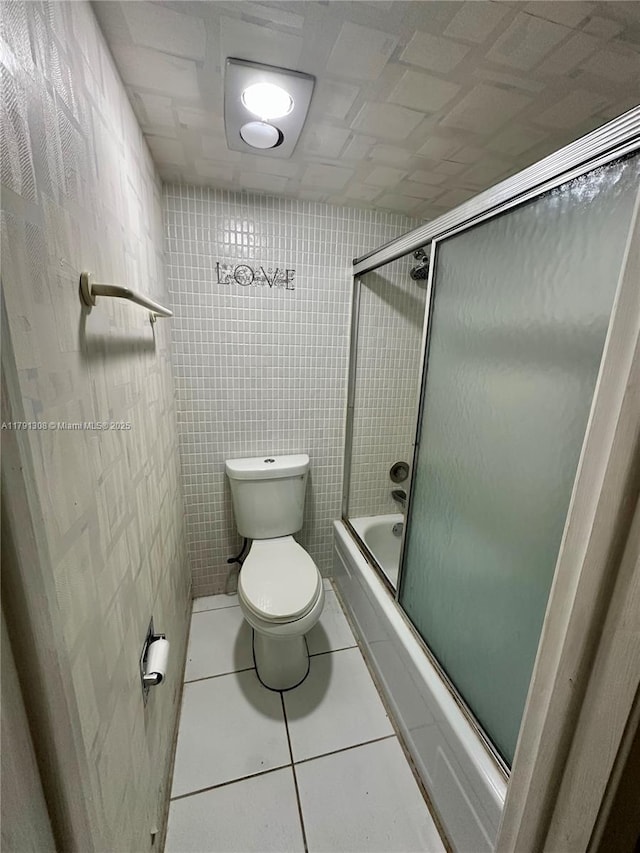 3301 Spanish Moss Ter Unit 302, Lauderhill, FL 33319 - bathroom featuring toilet, bath / shower combo with glass door, tile patterned flooring, and tile walls
