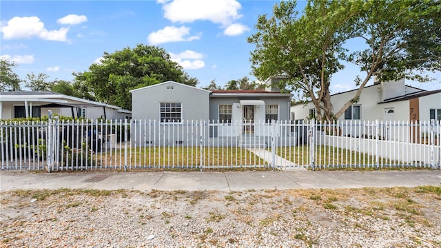 view of front facade featuring stucco siding, a front yard, and a fenced front yard