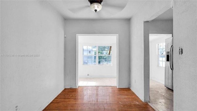 corridor featuring a wealth of natural light and wood finished floors