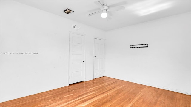 spare room featuring visible vents, a ceiling fan, and light wood-style flooring
