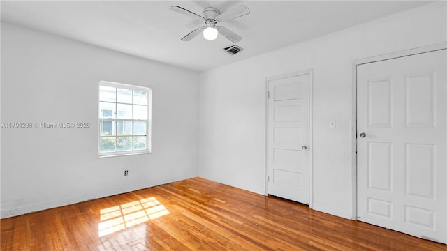 unfurnished bedroom with visible vents, a ceiling fan, and wood-type flooring