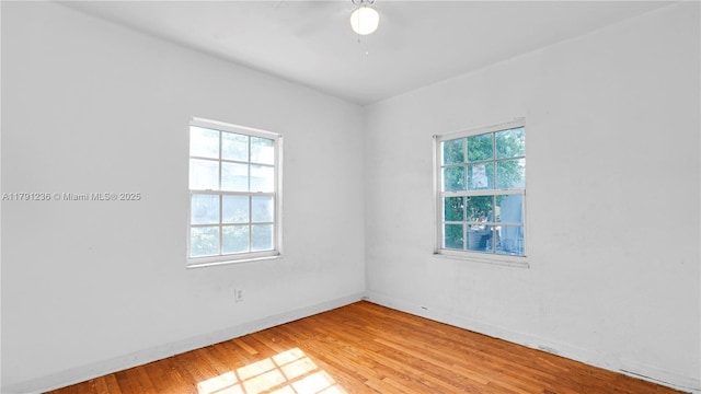 empty room featuring a ceiling fan, light wood-style flooring, and baseboards