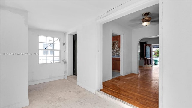 hall with baseboards and arched walkways