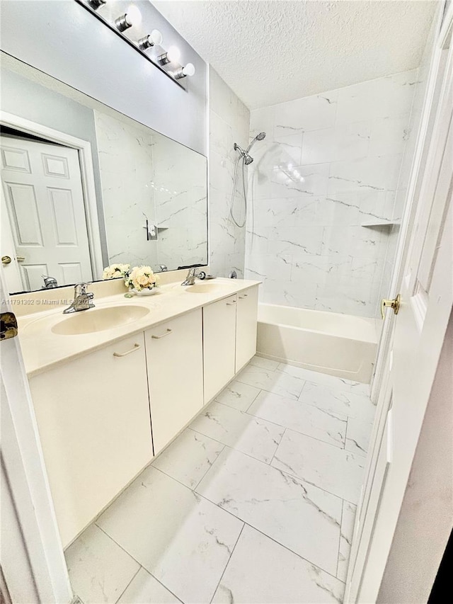 full bathroom featuring double vanity, marble finish floor, tub / shower combination, a textured ceiling, and a sink