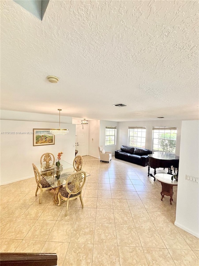 dining space featuring a textured ceiling and light tile patterned floors