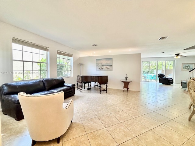 living area featuring light tile patterned flooring, ceiling fan, and visible vents