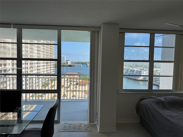 301 174th St Unit 1105, Sunny Isles Beach, FL 33160 - bedroom featuring a water view, tile patterned floors, a textured ceiling, and baseboards