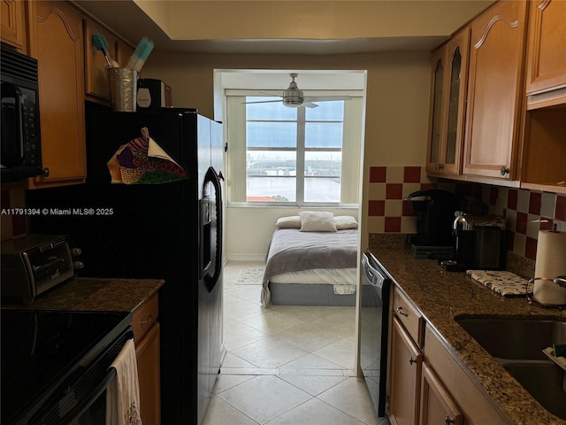 kitchen featuring brown cabinetry, black microwave, dishwashing machine, a ceiling fan, and a toaster