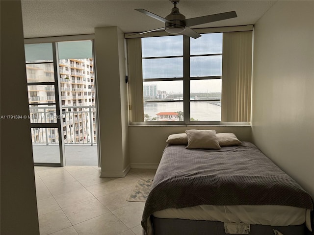 bedroom featuring light tile patterned floors, access to outside, a ceiling fan, and floor to ceiling windows