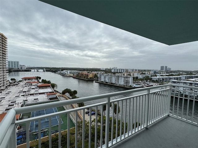 balcony featuring a water view and a city view