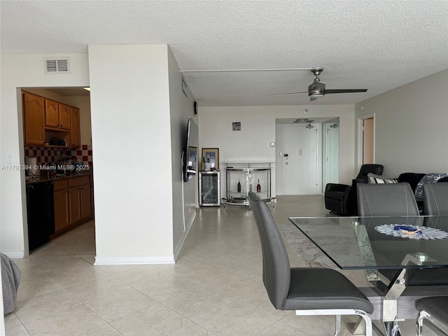 dining area with light tile patterned floors, a textured ceiling, visible vents, and ceiling fan