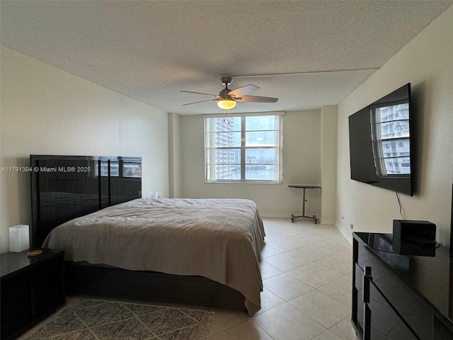 bedroom with light tile patterned floors, a ceiling fan, and a textured ceiling