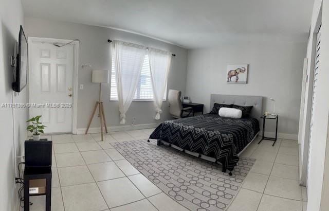 tiled bedroom featuring baseboards