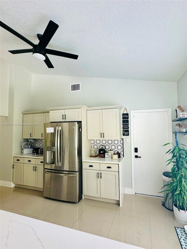 kitchen with light countertops, backsplash, visible vents, stainless steel refrigerator with ice dispenser, and a ceiling fan