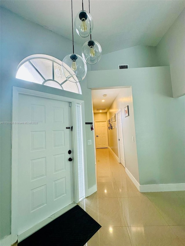 foyer entrance with baseboards, visible vents, and light tile patterned floors