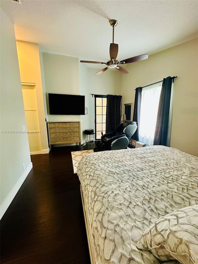 bedroom featuring baseboards, wood finished floors, and a ceiling fan