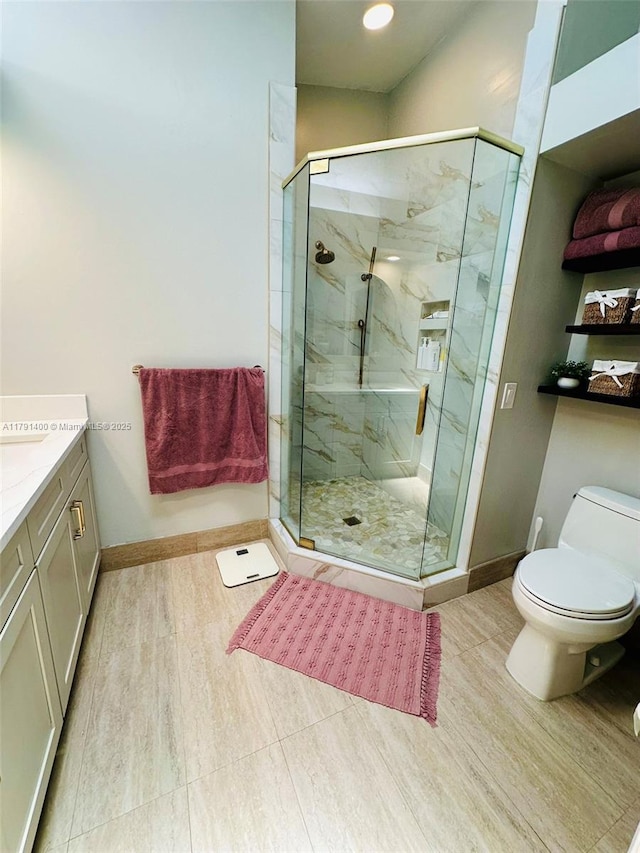 full bathroom with toilet, a marble finish shower, vanity, and baseboards