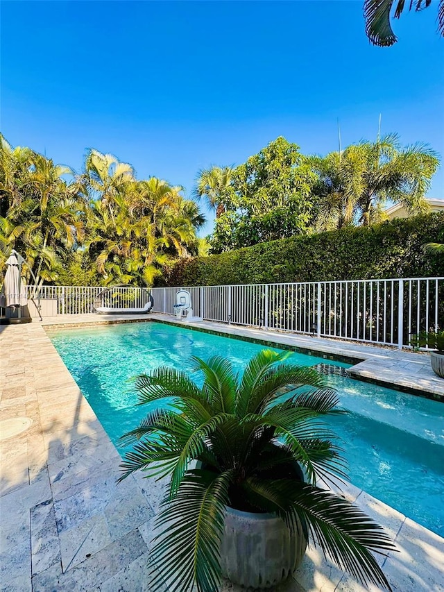 view of pool with a fenced in pool, a patio area, and fence