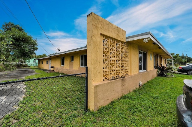 1910 NW 72nd St, Miami, FL 33147 - view of home's exterior featuring a yard, stucco siding, and fence