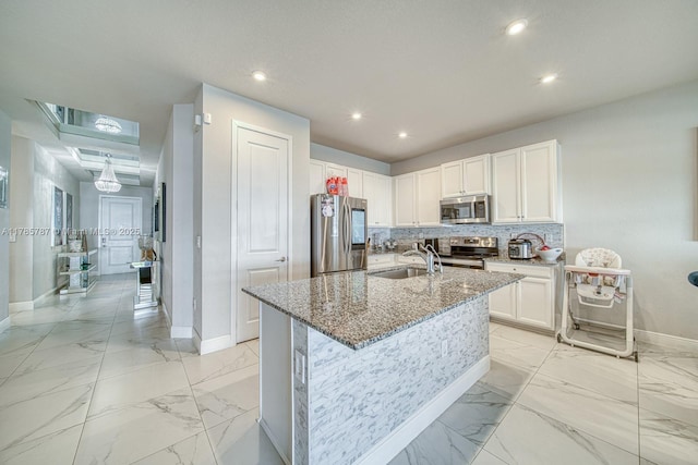 kitchen with a sink, appliances with stainless steel finishes, baseboards, and marble finish floor